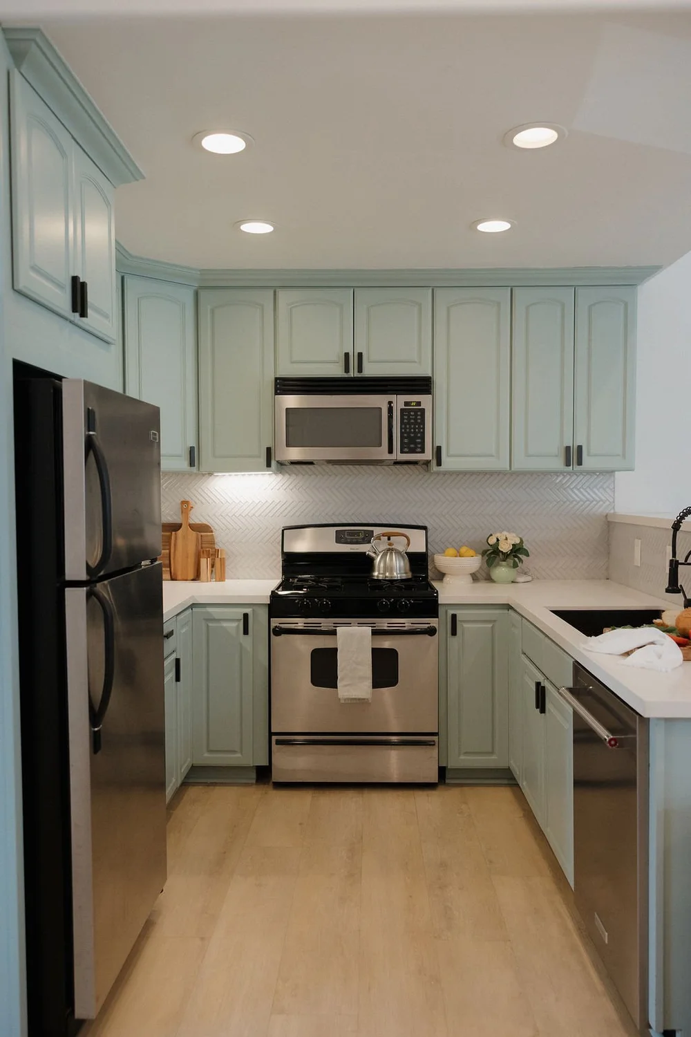 The sage green kitchen in The East Cove townhome