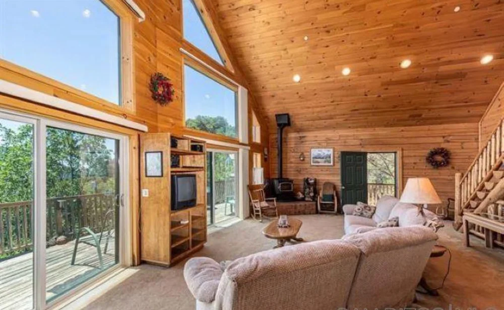 Before: Living room with a beige sofa and sliding doors at Dark Moon Chalet in Julian