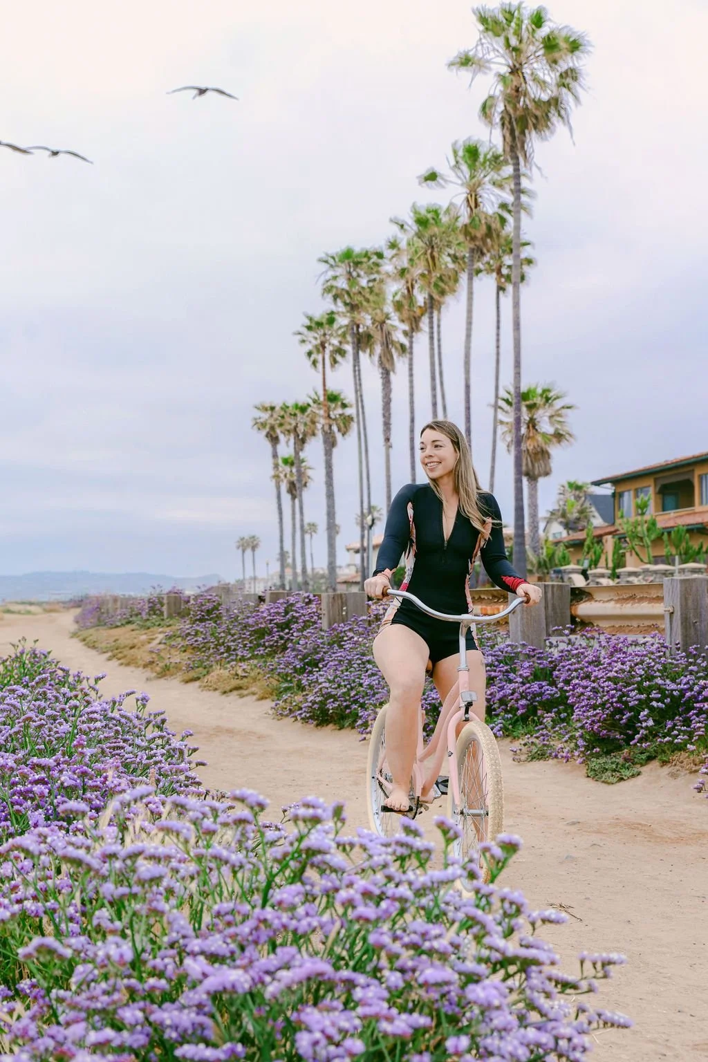 Riding a beach cruiser past the palms on the Ocean Beach path in San Diego