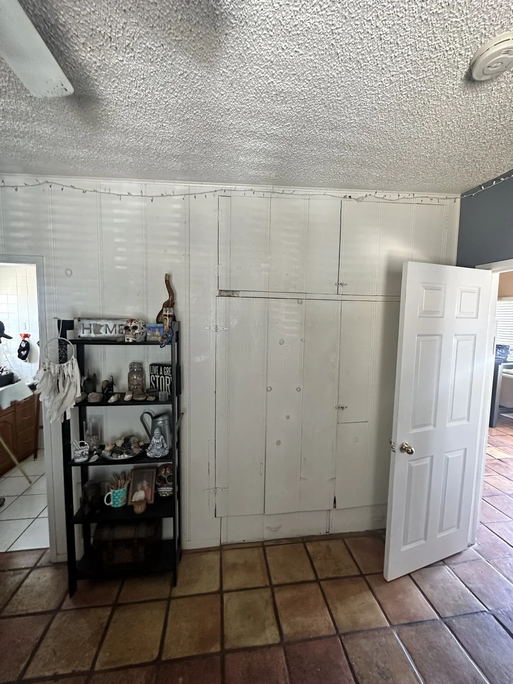 Before: Room with a white paneled storage wall at Clementine C in Oceanside