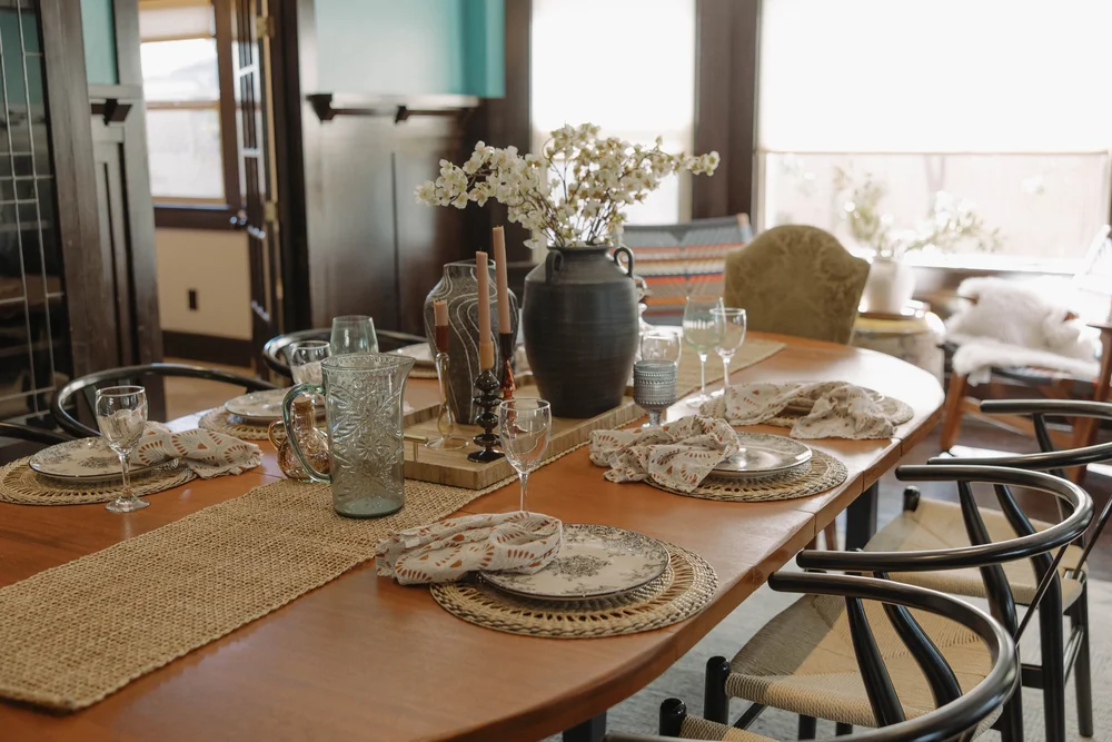 The dining table set for a group at Palm Parkside, under the bay windows