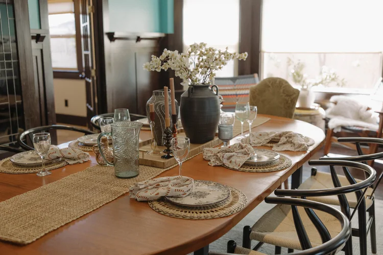 The dining table set for a group at Palm Parkside, under the bay windows