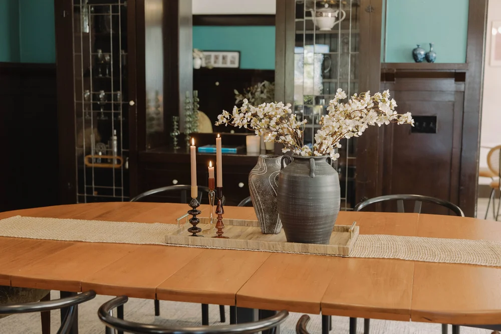 Flowers in stoneware vases on the long dining table at Palm Parkside