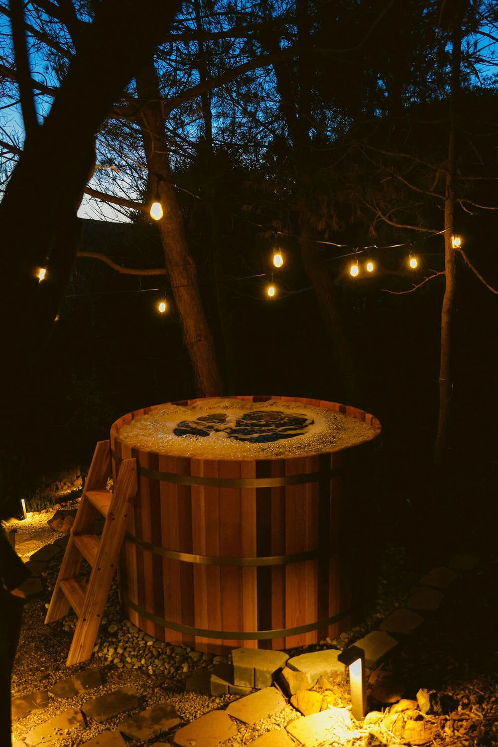 Cedar hot tub under string lights at night — Julian California cabin