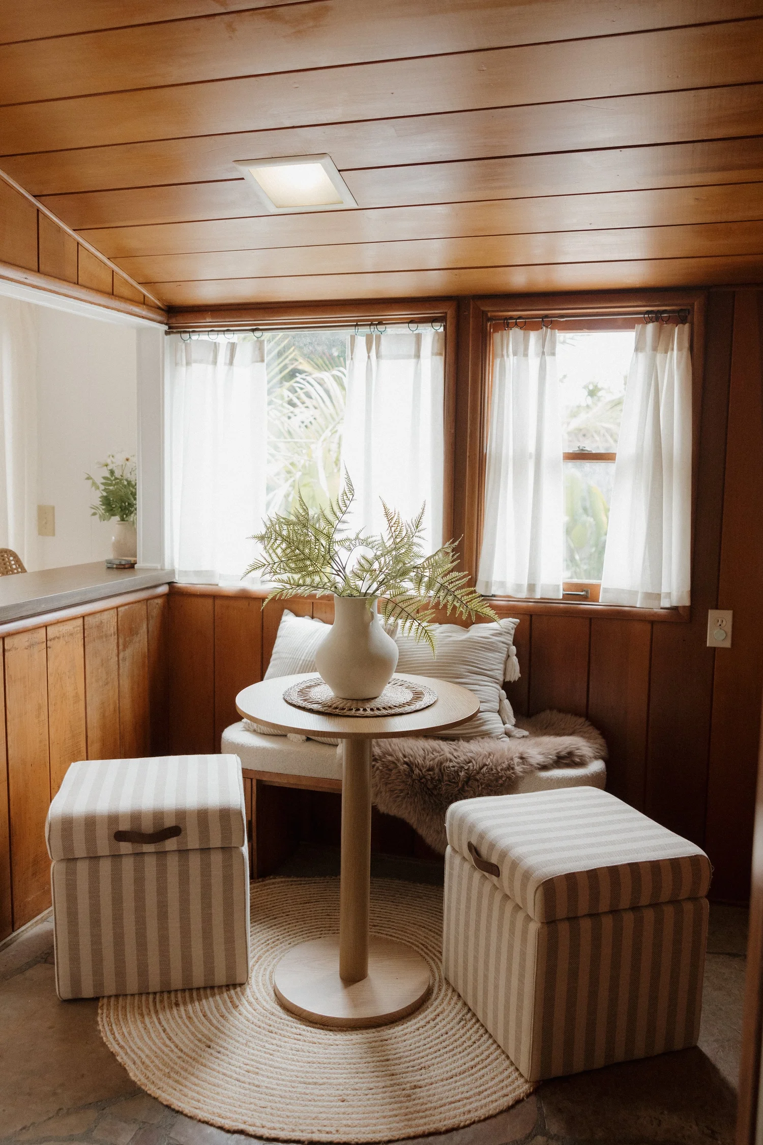 The wood-paneled breakfast nook at Wavehouse with a bay window and a round table