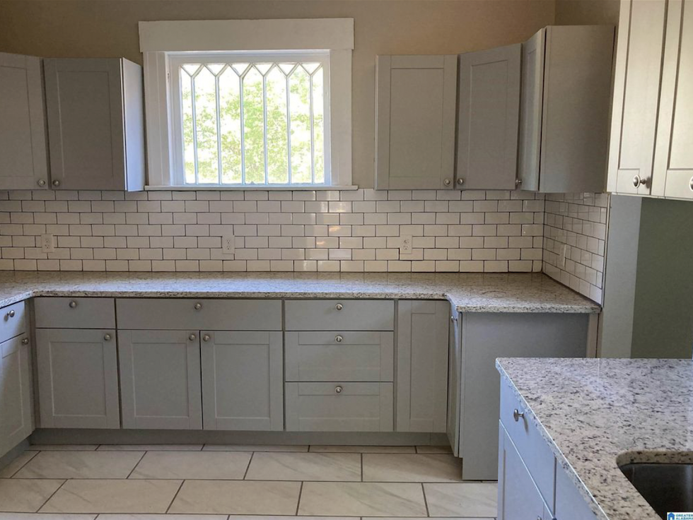 Before: Empty kitchen with gray cabinets and subway tile at Elmsgate in Birmingham