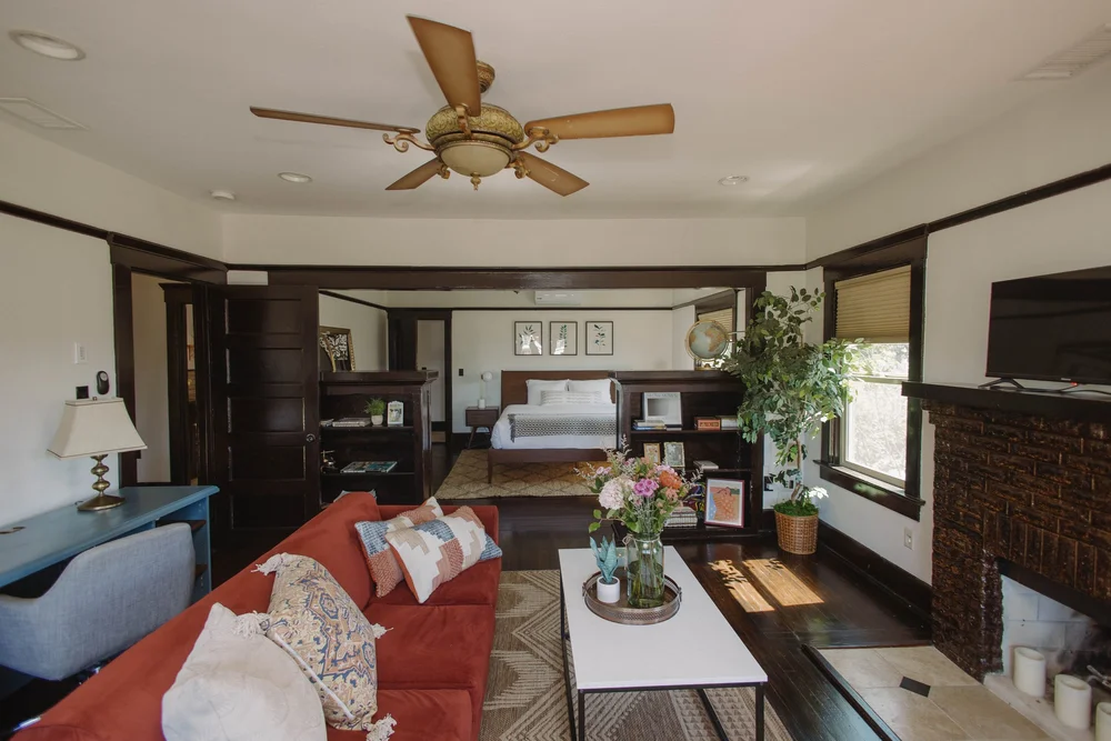 The upstairs master suite living room at Palm Parkside, with a red velvet sofa and dark wood trim