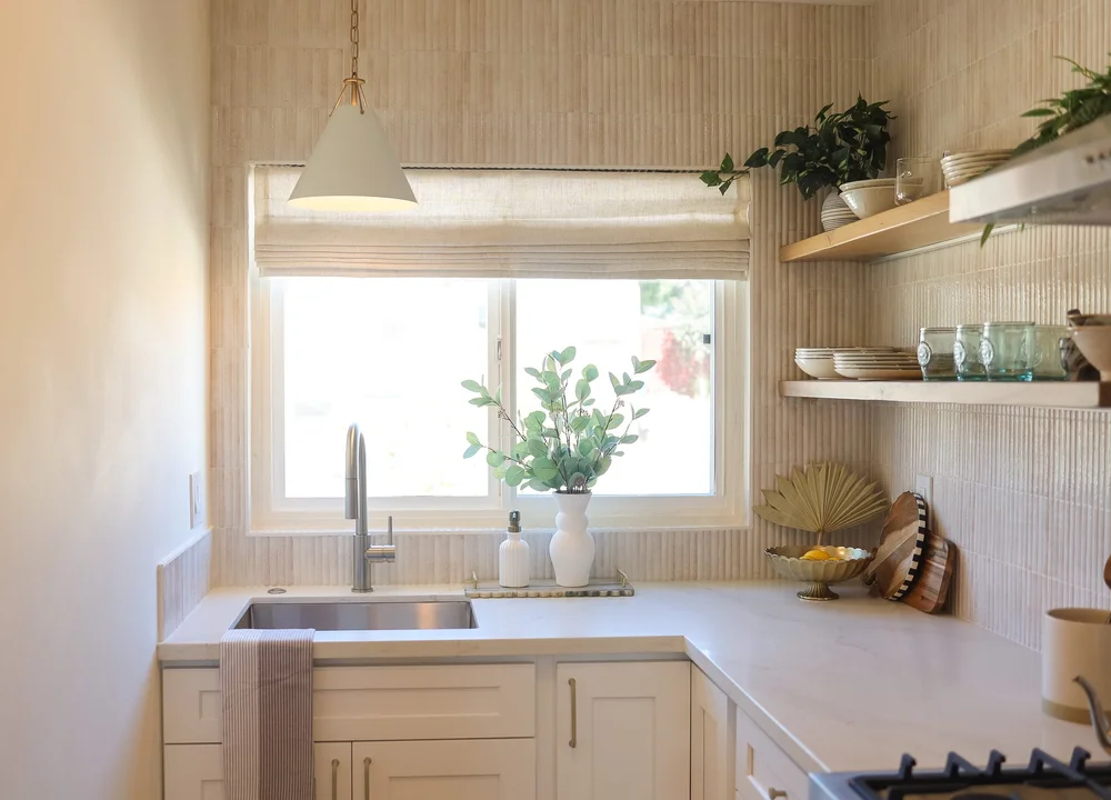 The kitchen with warm wood shelves and a window over the sink in Unit Three at The Swell, Oceanside