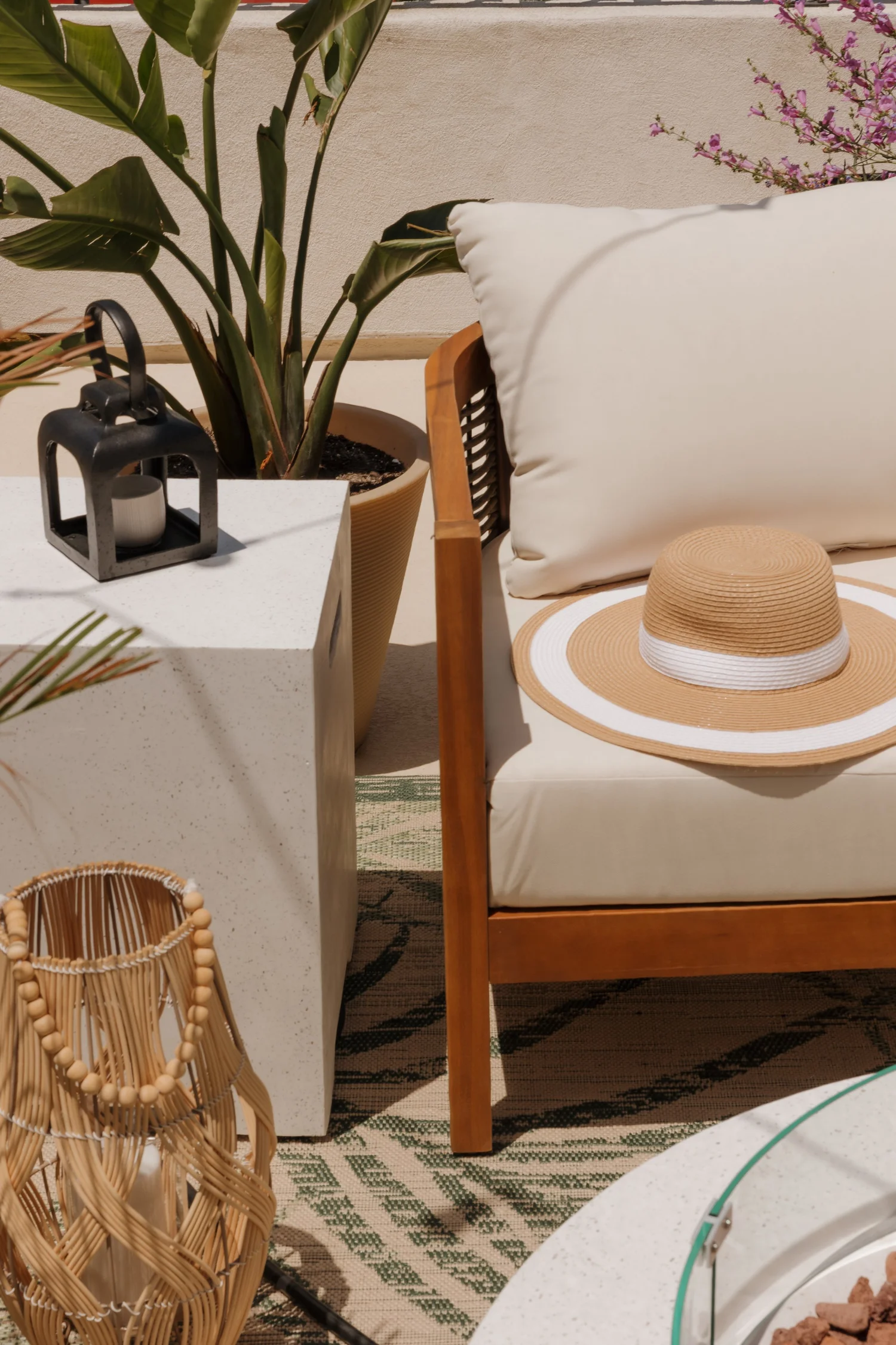 A straw sun hat on a white outdoor chair on the balcony at Coastal Palm in Pacific Beach