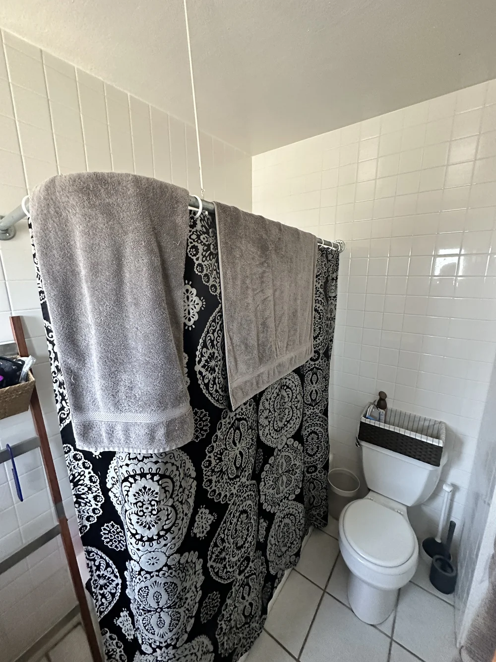 Before: Bathroom with a patterned shower curtain at Clementine C in Oceanside