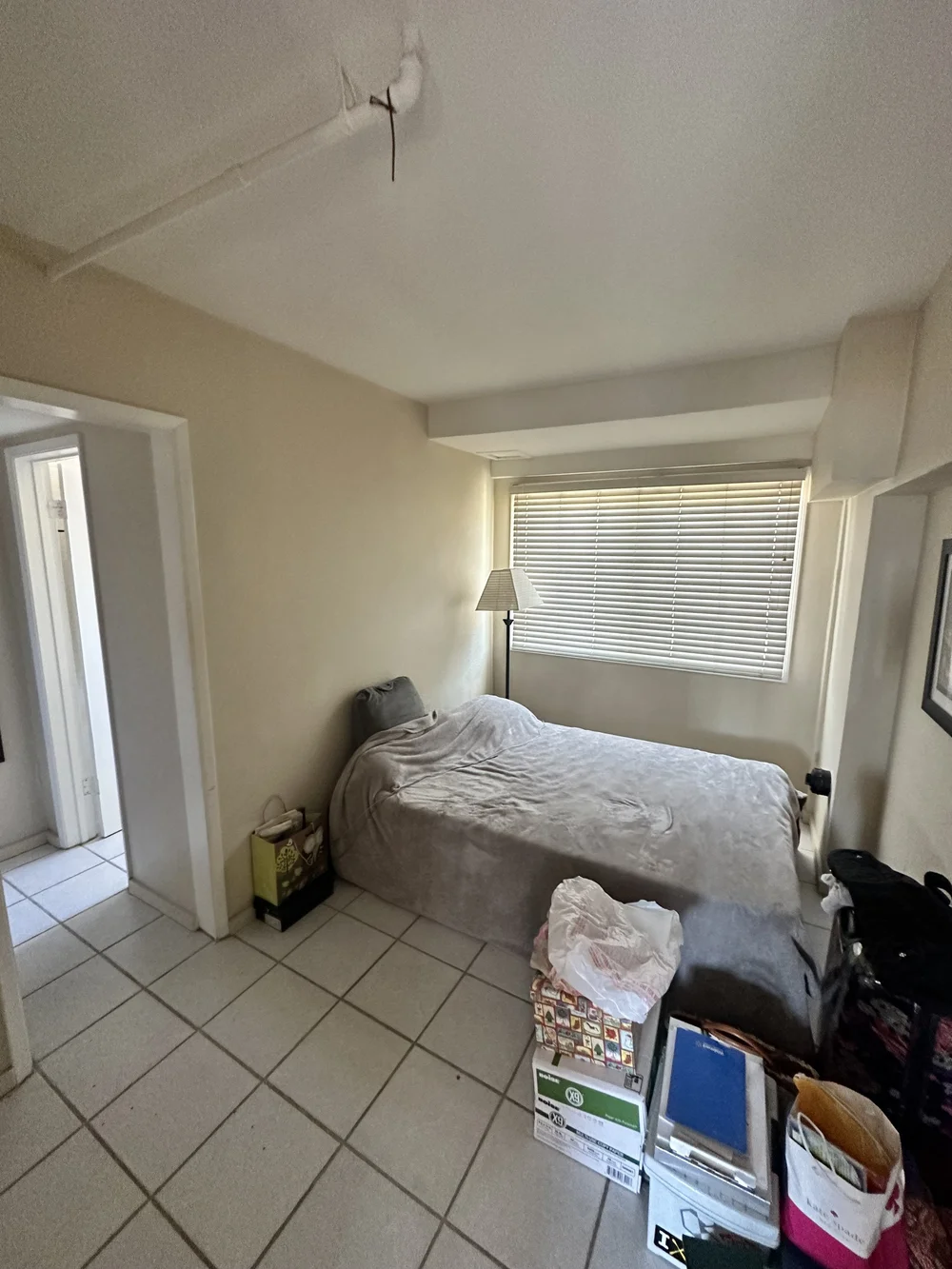 Before: Bedroom with a tile floor and boxes at Clementine A in Oceanside