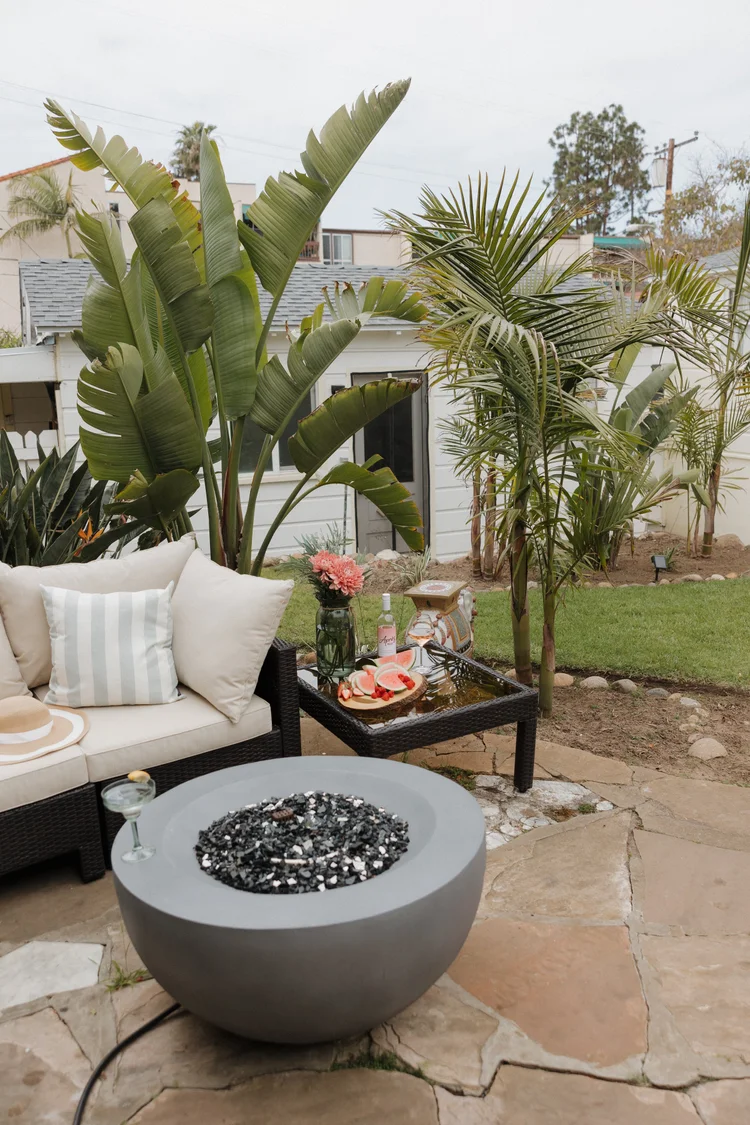 The big fenced backyard at Wavehouse with grass, a fire pit and landscaping
