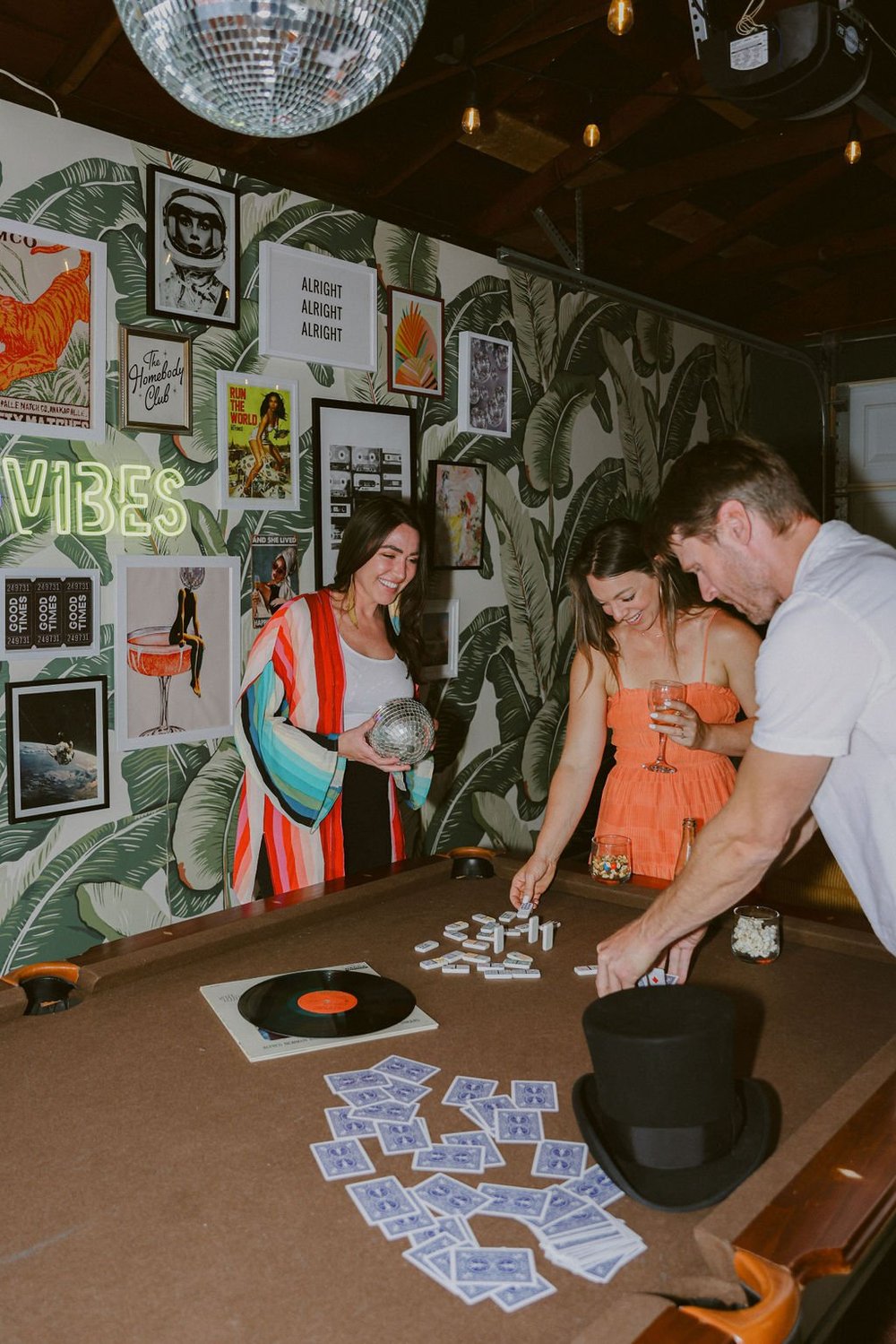 Friends playing cards on the pool table in the game room at Palm Parkside