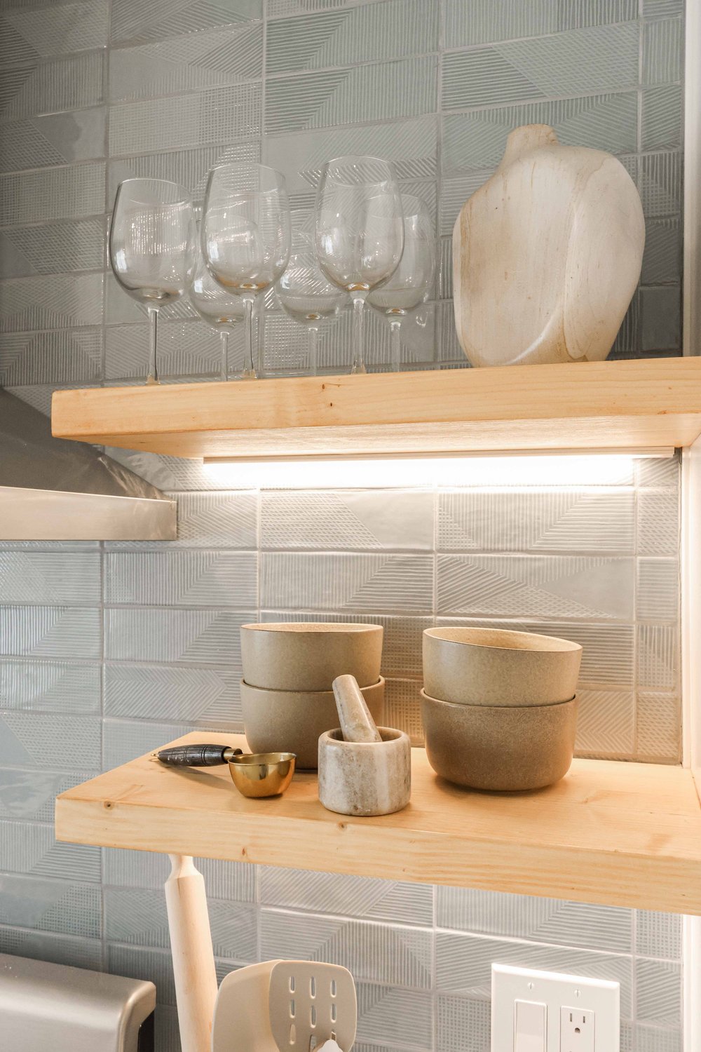 Open wood shelves with glassware and bowls in Unit One at The Swell, Oceanside