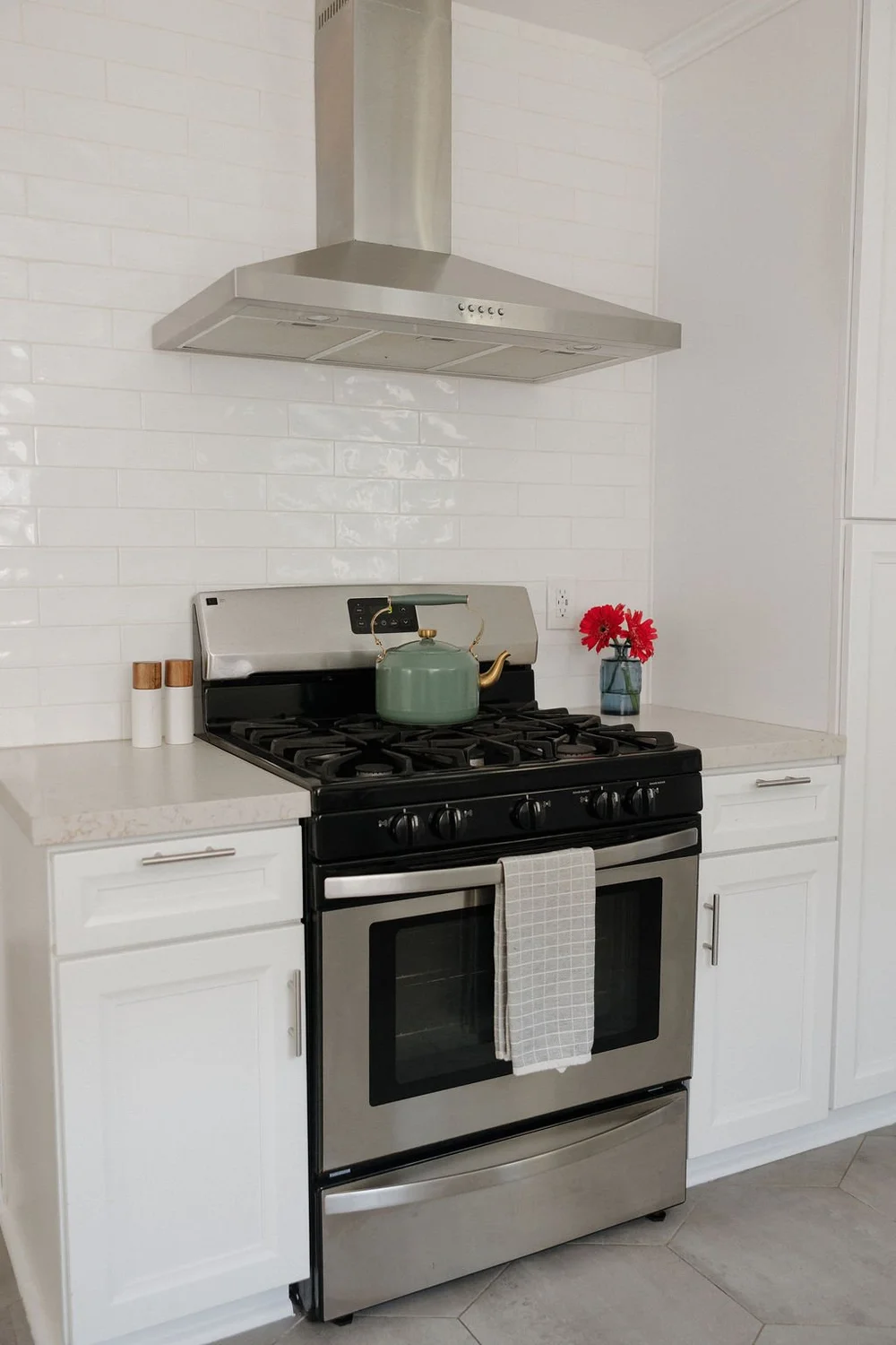 The kitchen in The Villa with a gas range and white tile