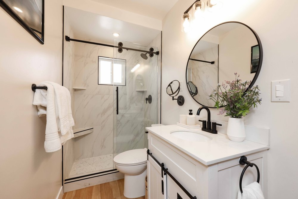 The bathroom with a glass shower and white vanity in Unit Two at The Swell, Oceanside