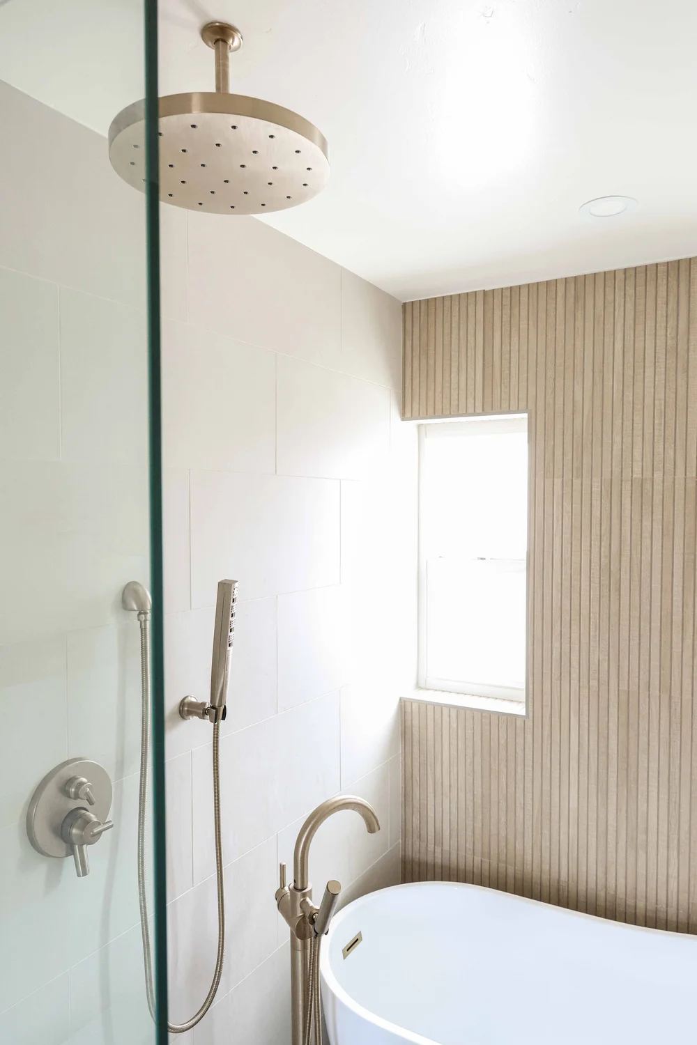 The glass-enclosed shower beside the soaking tub in Unit One at The Swell, Oceanside