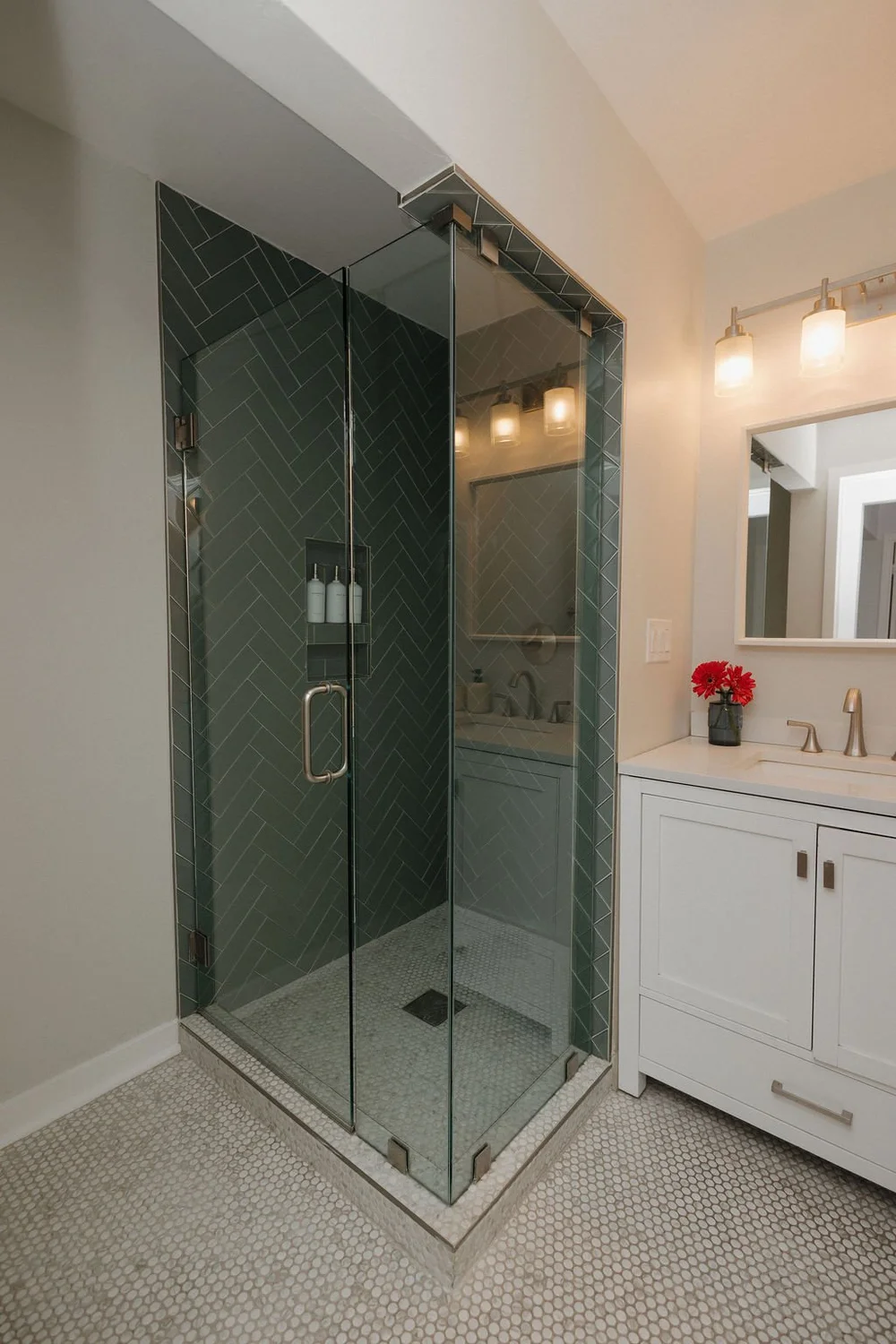 The second bathroom in The Villa with a green tile walk-in shower and a white vanity