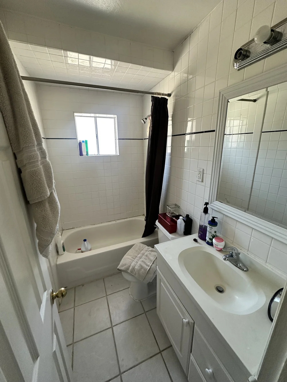 Before: Bathroom with a tub and white vanity at Clementine A in Oceanside