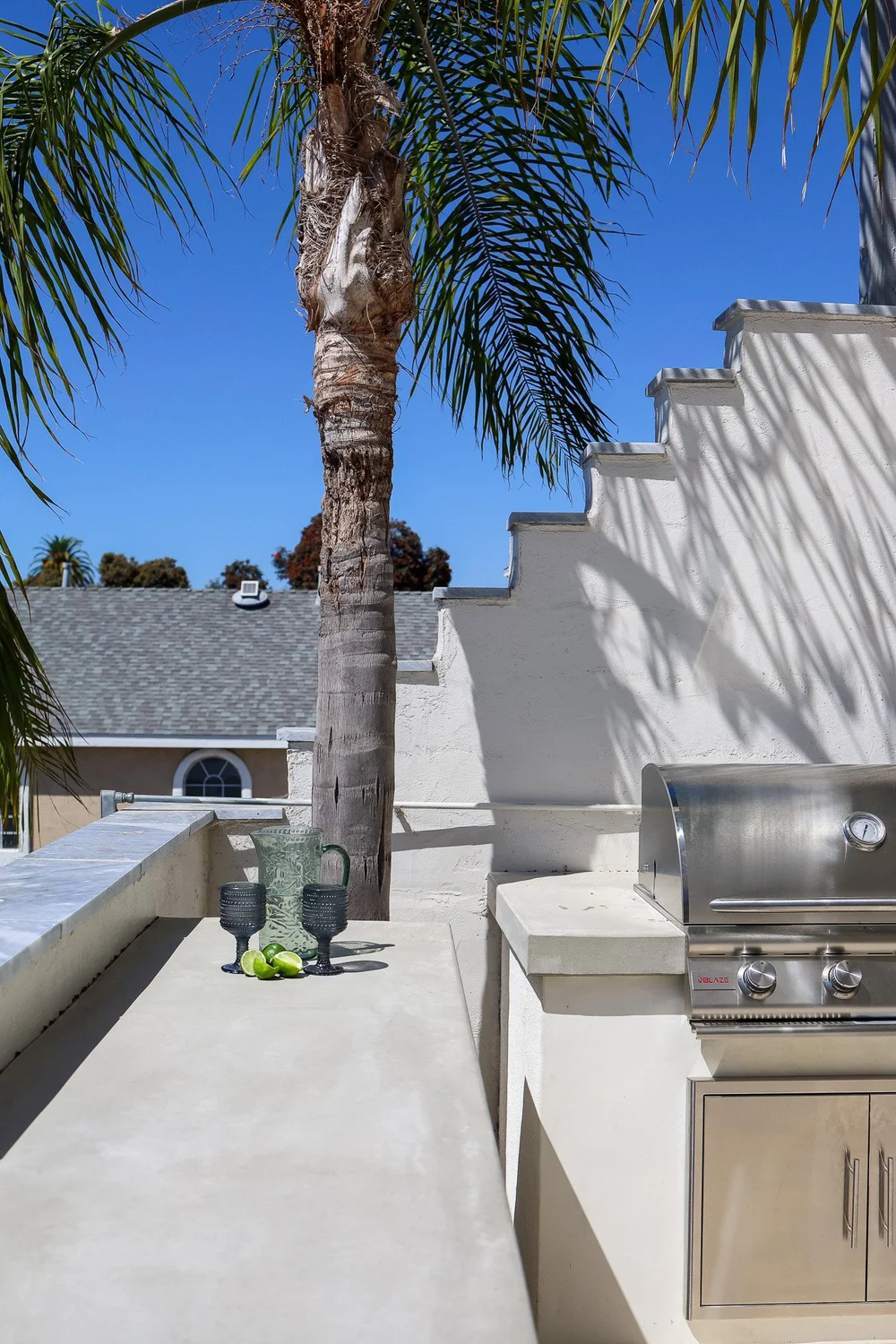 The built-in gas grill on the shared patio at The Swell, under a palm tree
