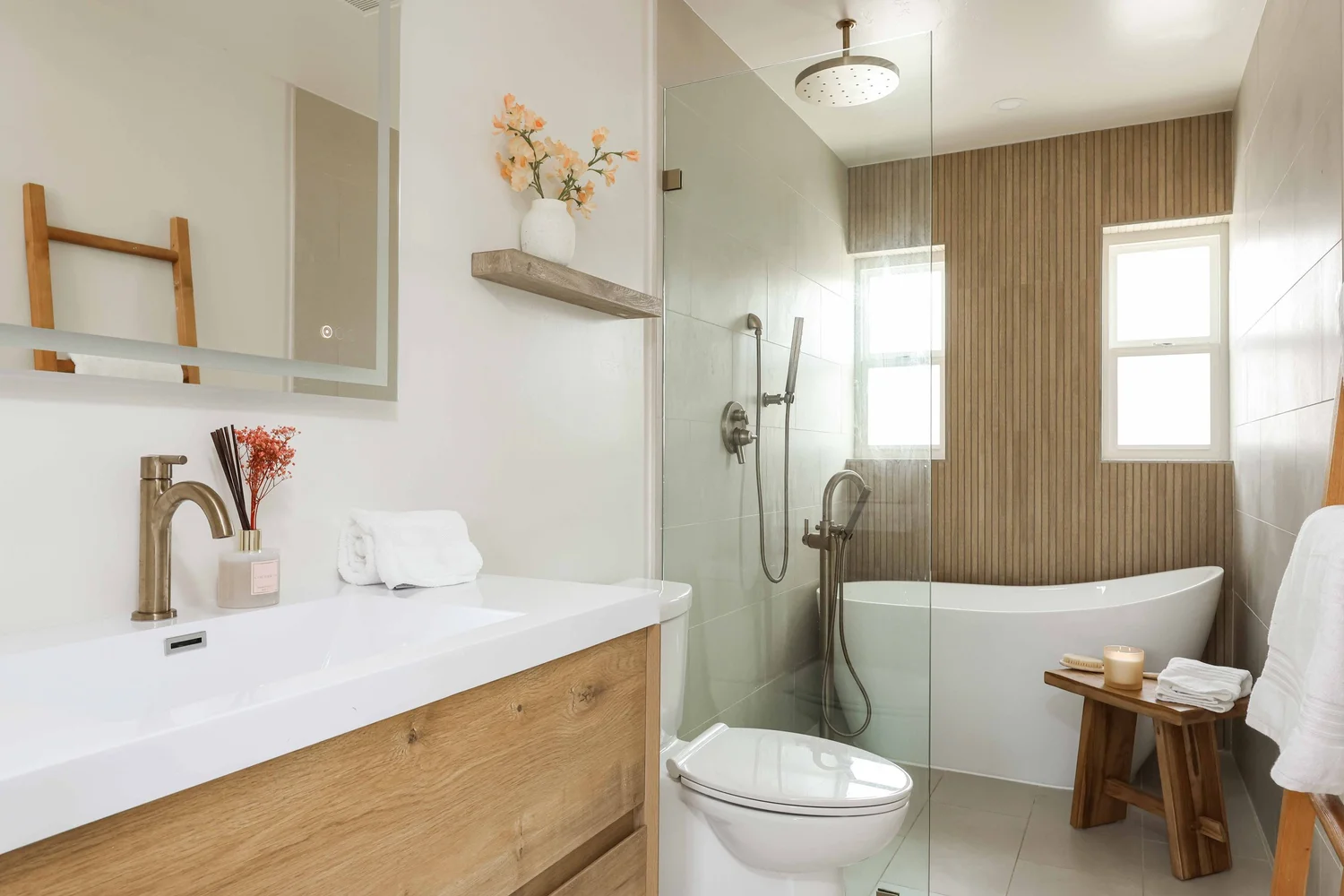 Spa bathroom with a wood vanity, walk in shower and soaking tub at Clementine B in Oceanside, designed by Salt and Sky Lodging Co.