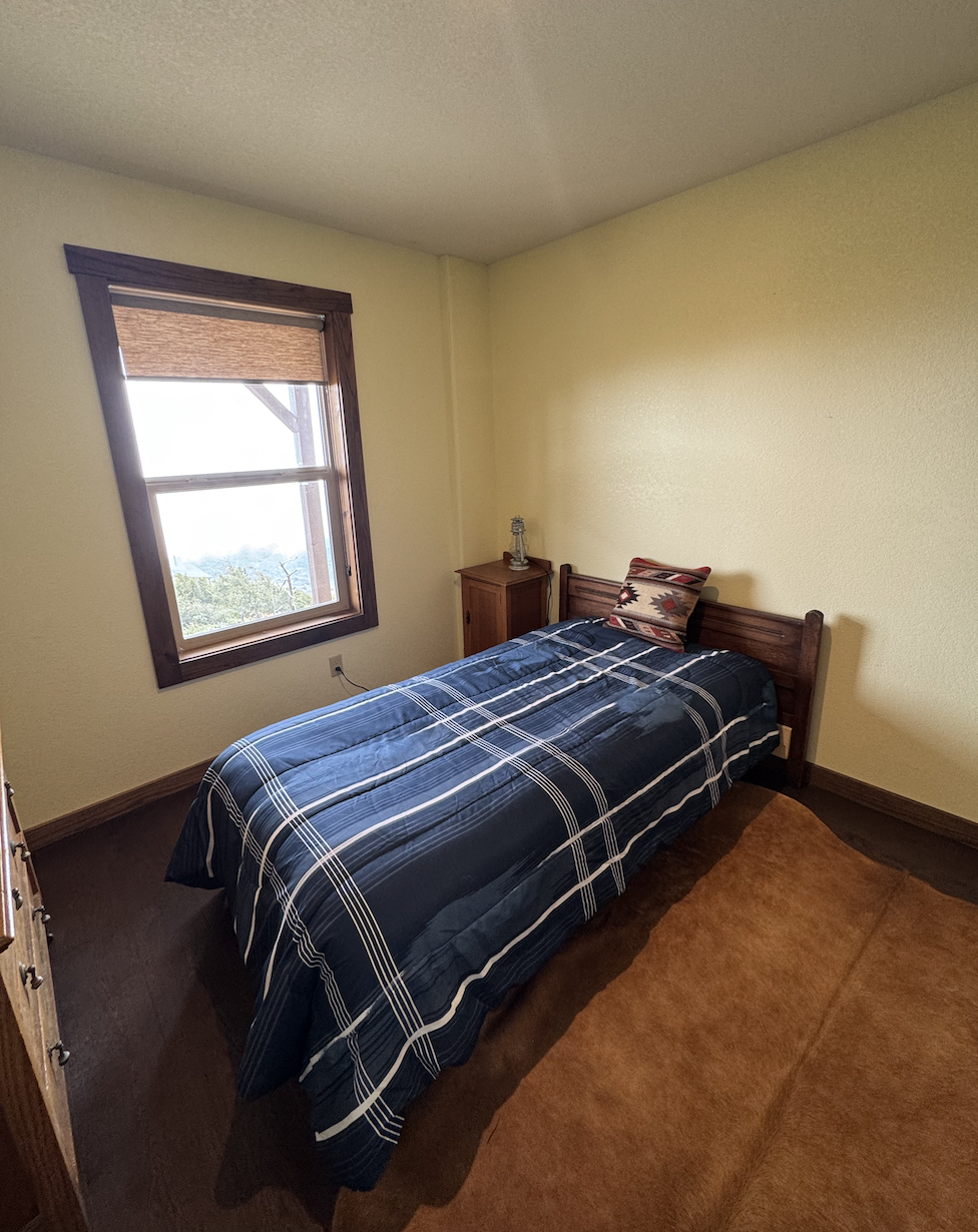 Before: small bedroom with a plaid bedspread