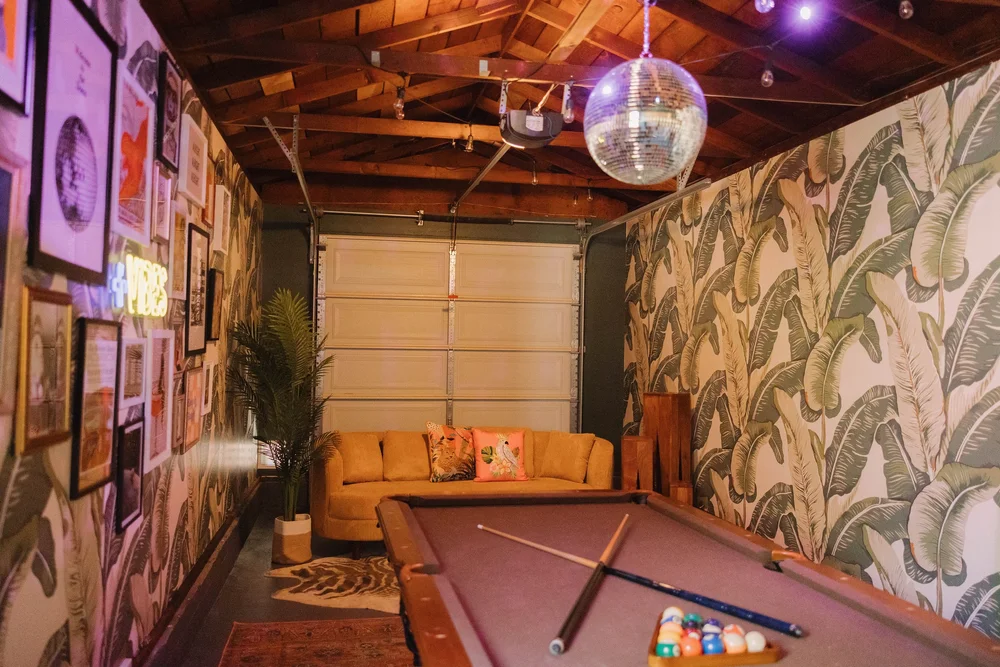 The disco ball, lounge and pool table in the game room at Palm Parkside