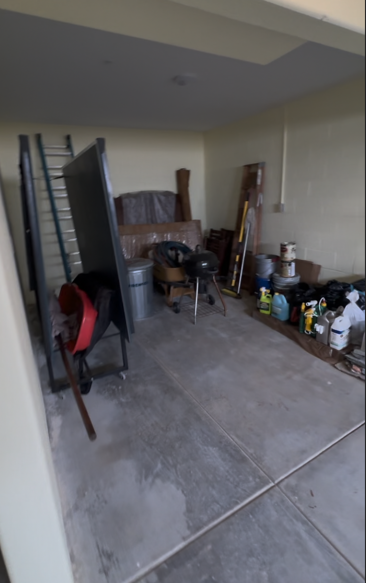 Before: garage with a concrete floor and stored items