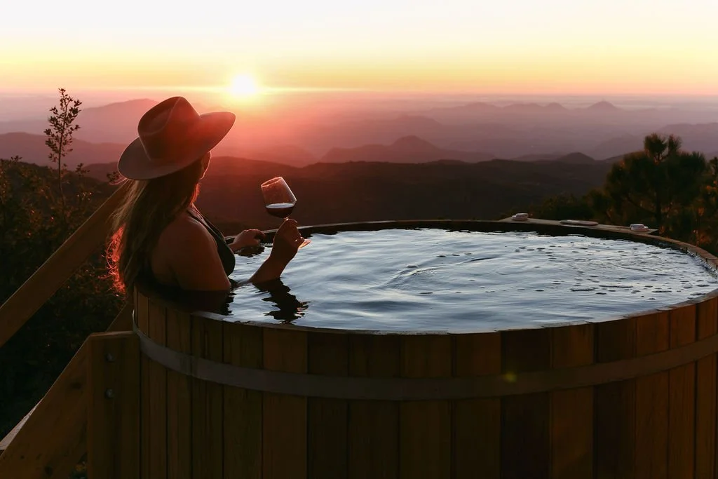 A glass of red in the cedar hot tub at sunset over the mountains at Wild Moon Ranch near Julian