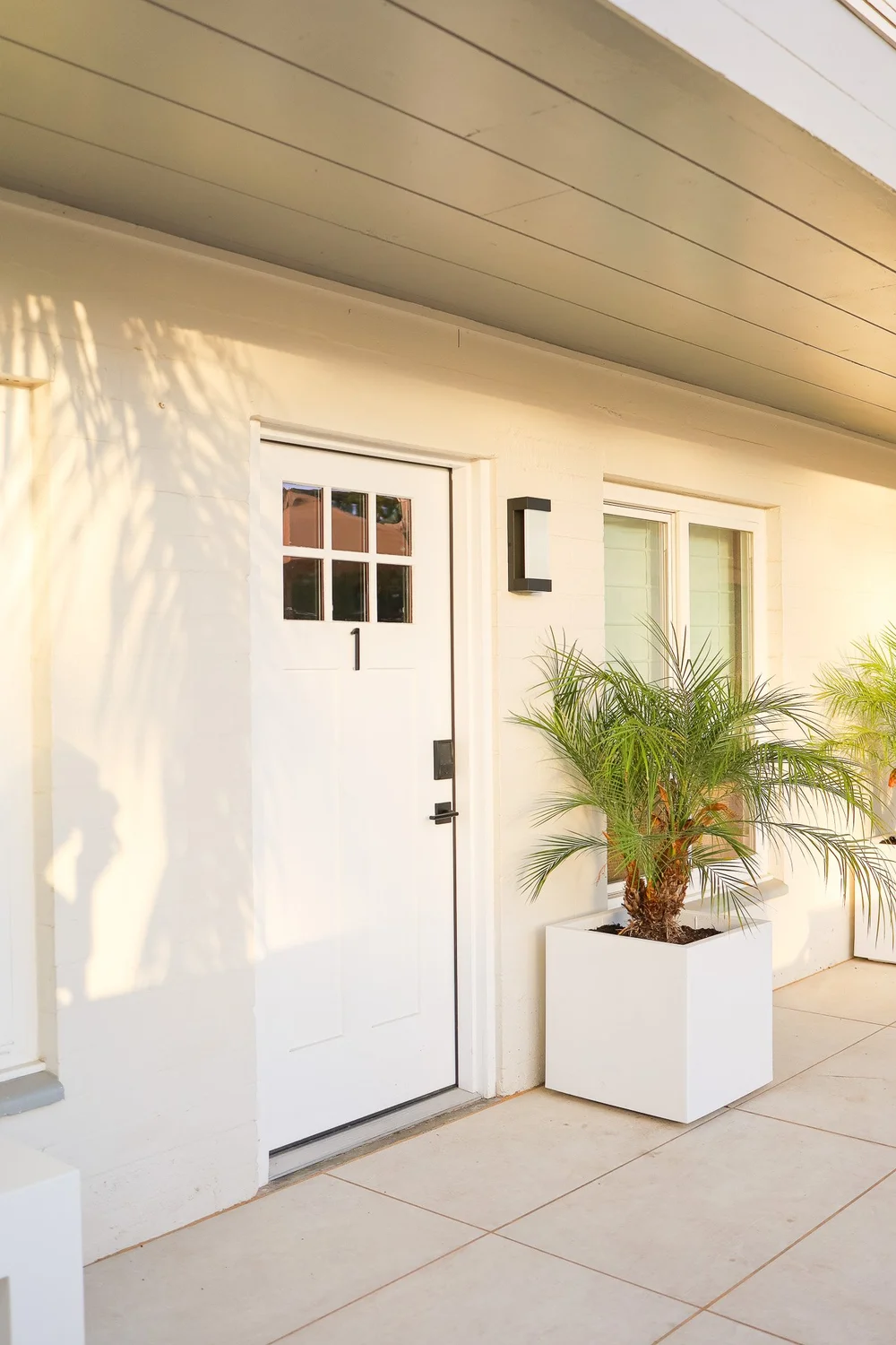 The front door of Unit One with palm planters on the patio in Unit One at The Swell, Oceanside