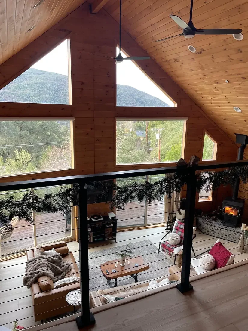 Guest photo: the great room and A-frame windows seen from the loft