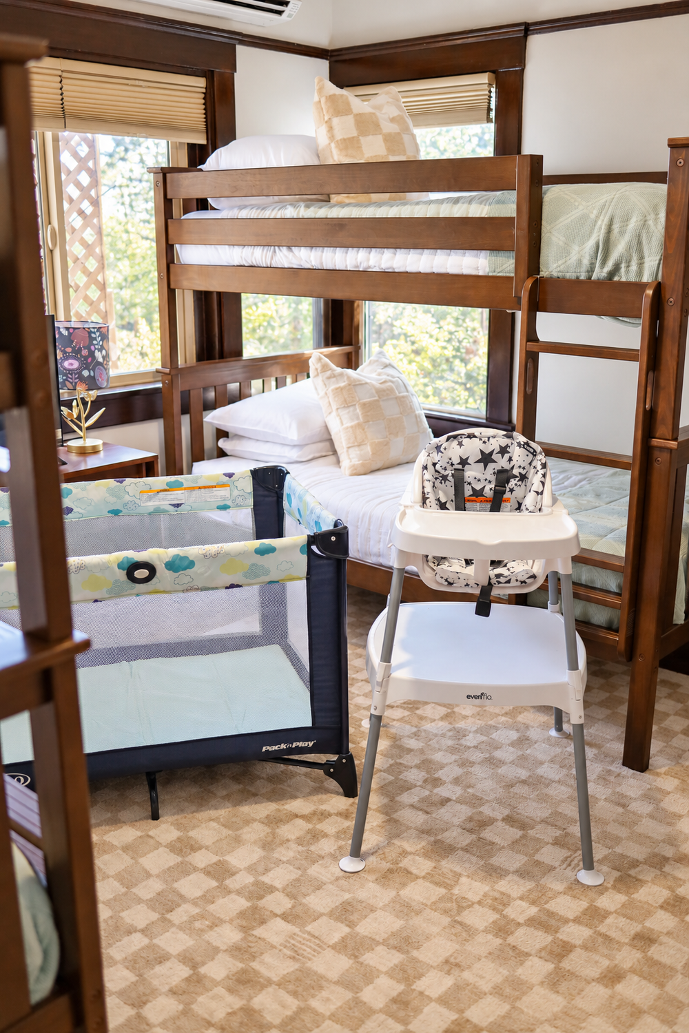 The bunk room at Palm Parkside set up for a family, with a Pack n Play and a high chair