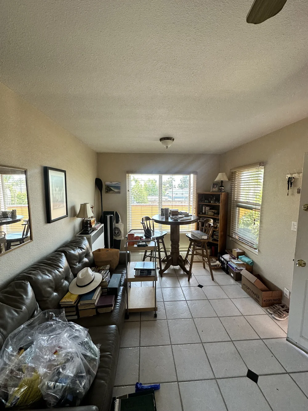 Before: Living room with a leather sofa and tile floor at Clementine A in Oceanside