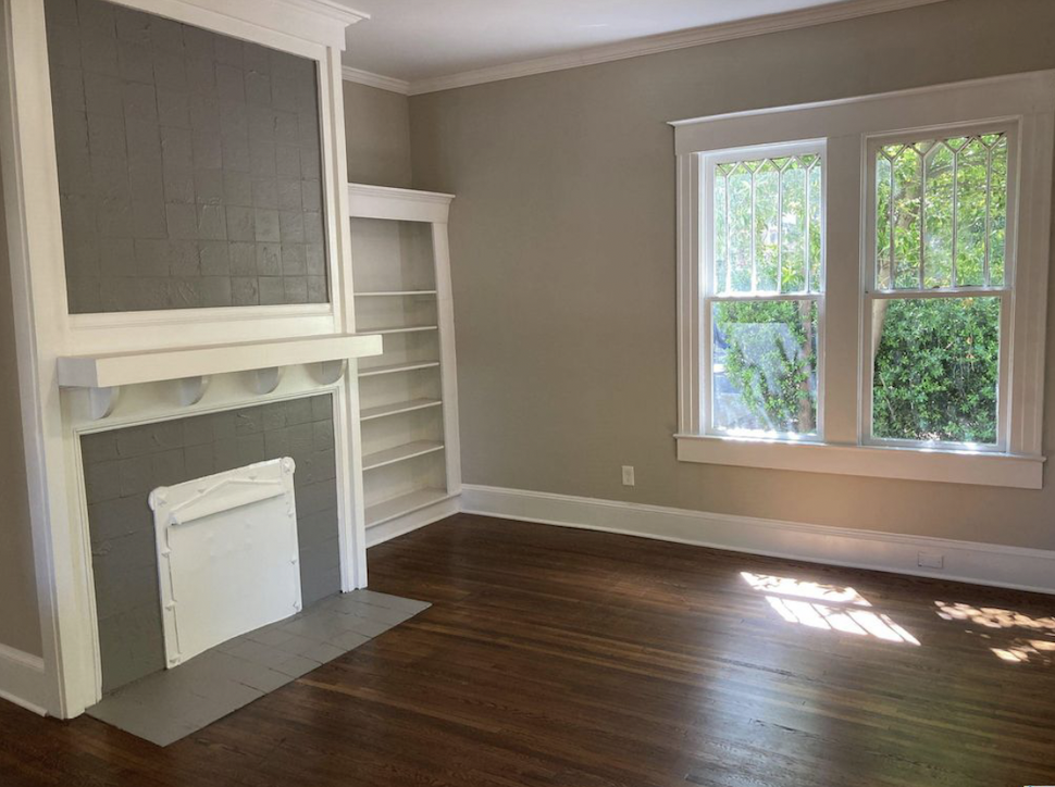 Before: Empty living room with a fireplace and built in shelves at Elmsgate in Birmingham