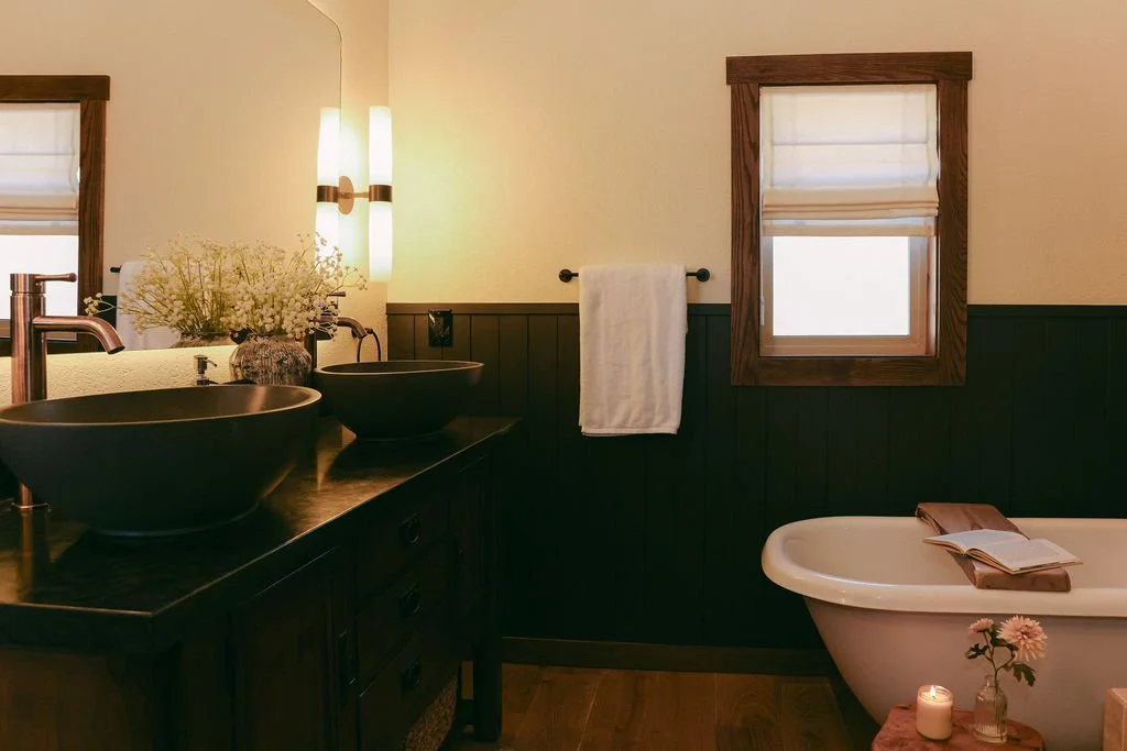Bathroom with dark green wainscoting and a white towel on a black bar