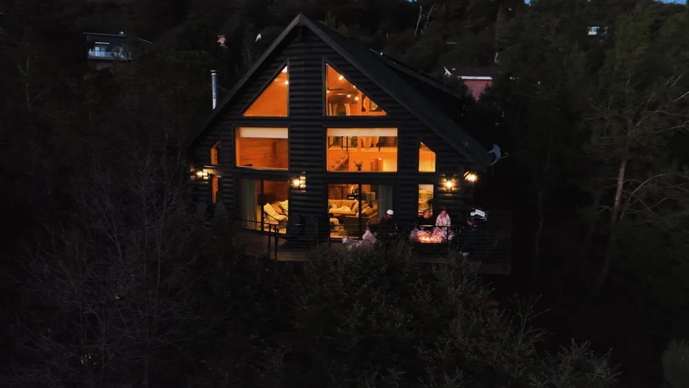Dark Moon Chalet lit up at dusk in the pines — Julian California