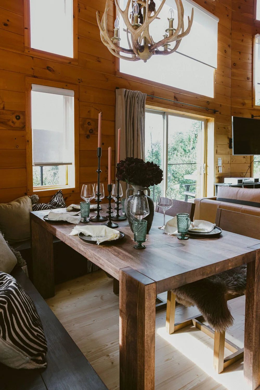 Dining table set for dinner under the A-frame windows — Julian CA cabin