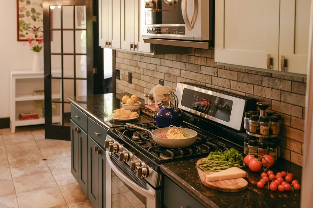 The gas range in the main kitchen at Palm Parkside, with a brick backsplash