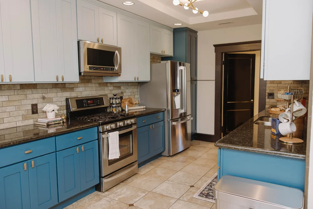 The main kitchen at Palm Parkside with blue cabinets and stainless steel appliances