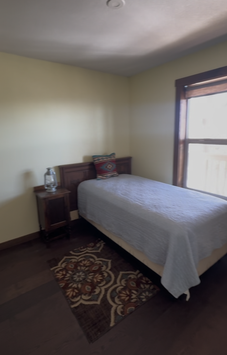 Before: bedroom with a single bed and patterned rug