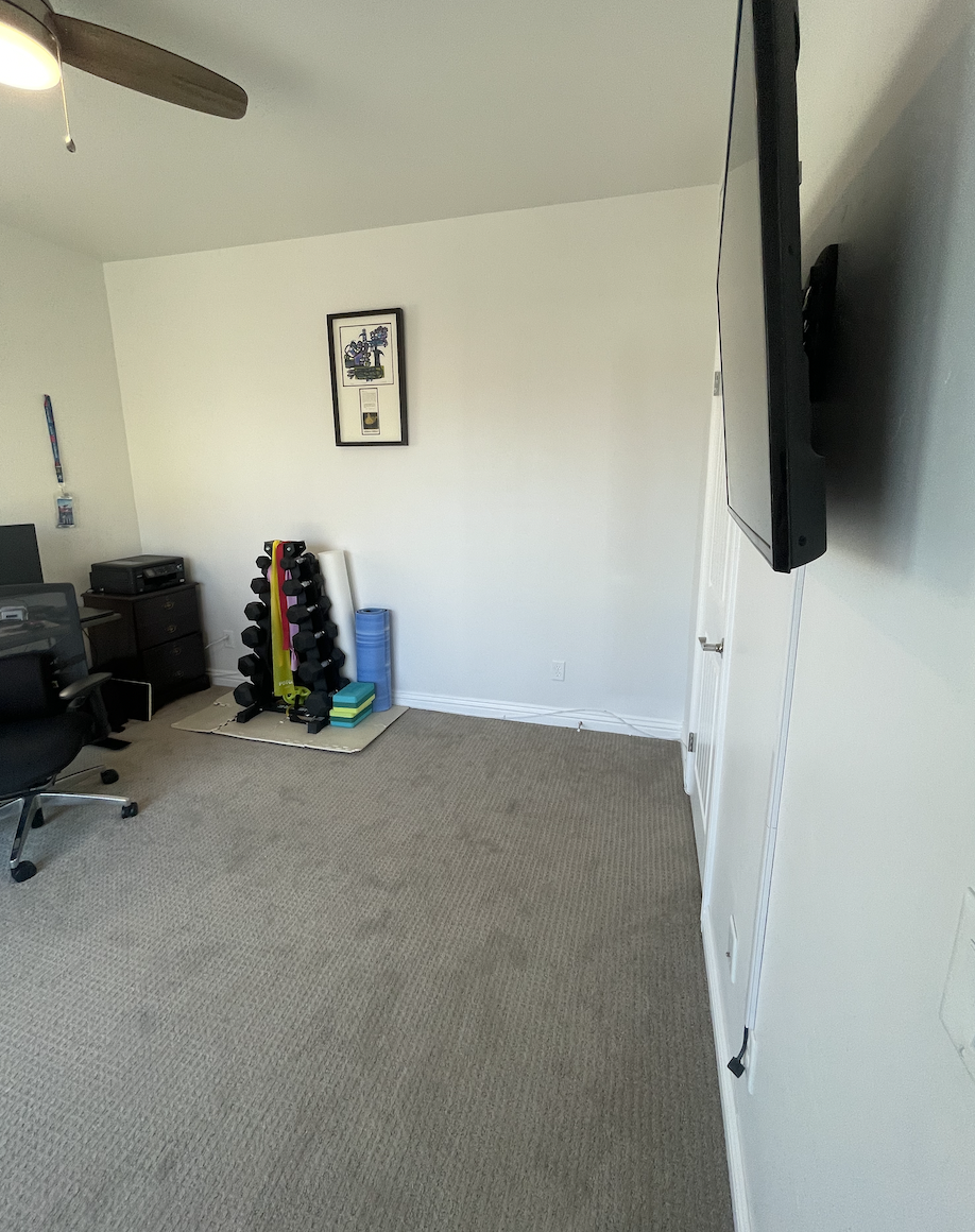 Before: Empty bedroom with workout weights at Coastal Palm in Pacific Beach