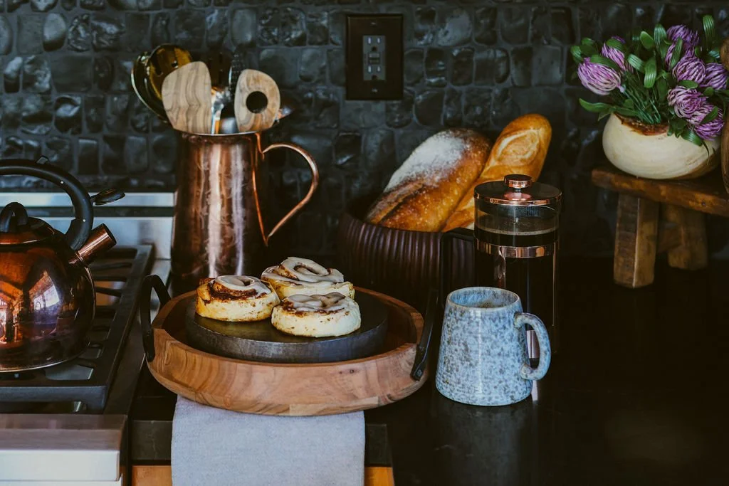 Pastries and coffee on a wood board in the cabin kitchen