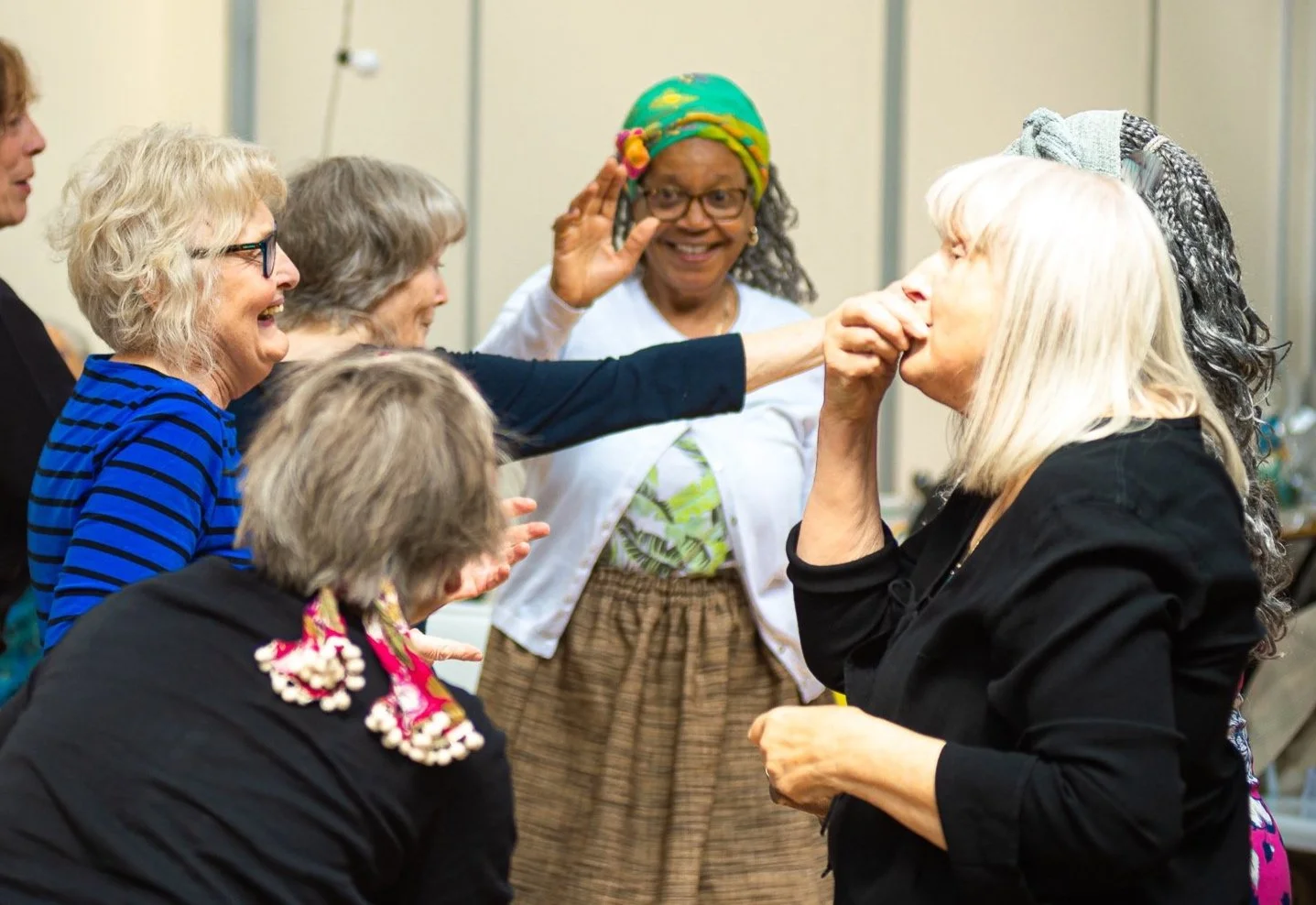 Women engaging in a lighthearted moment as they all enjoy each other's company.