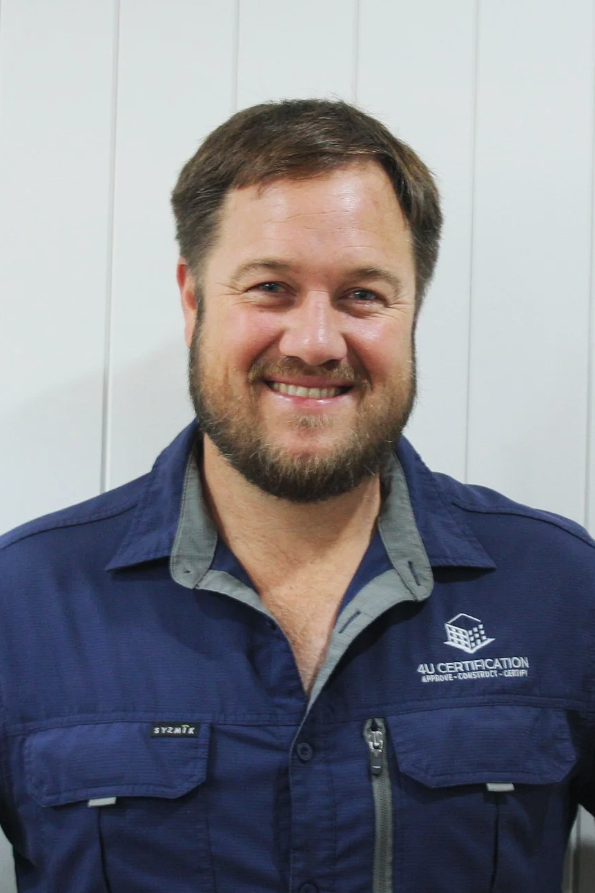 A smiling man with short brown hair, blue eyes, and a beard, wearing a navy blue jacket with a logo that reads '4U Certification' and a collared shirt underneath.