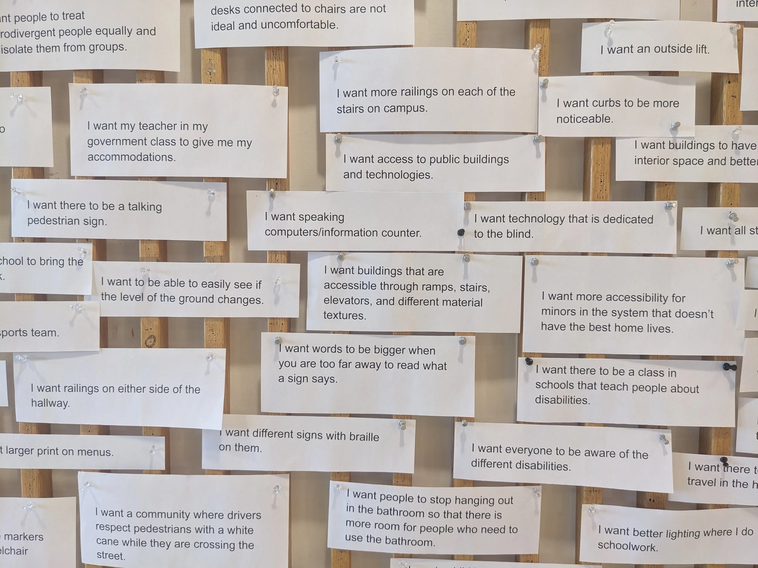 Discussion Activity with Carmen Papalia: "I Want" Statements for a More Just World. ID: Close-up view of many small pieces of white paper with black text read different "I want" statements, such as "I want buildings that are accessible through ramps,