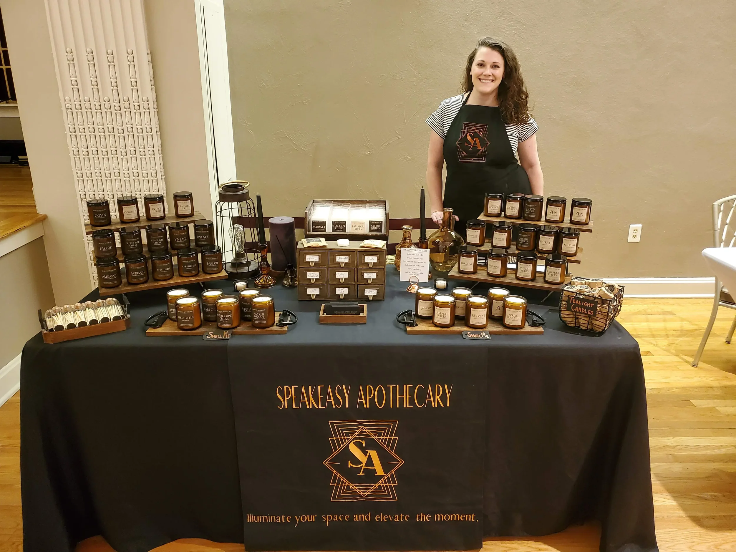 Stephanie, founder of Speakeasy Apothecary, at her market display — hand-poured coconut soy candles and home fragrance, Cincinnati Ohio area