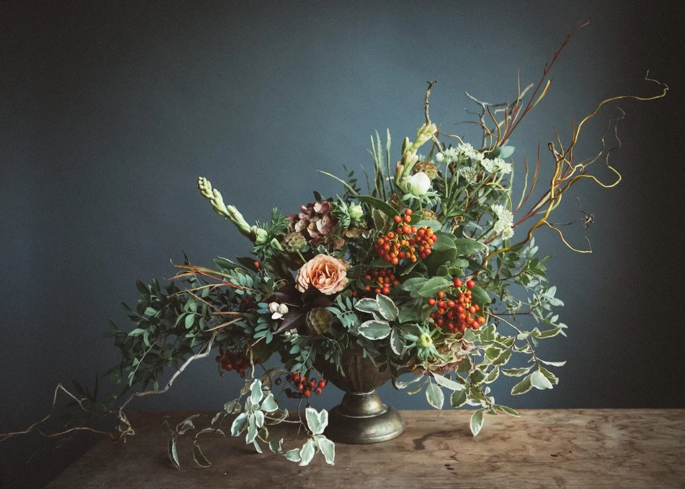 Dried floral arrangement in soft pinks and yellows – natural texture and gentle colour.
15. Wild, hand-tied bouquet in moody tones – expressive floral storytelling with a touch of drama.