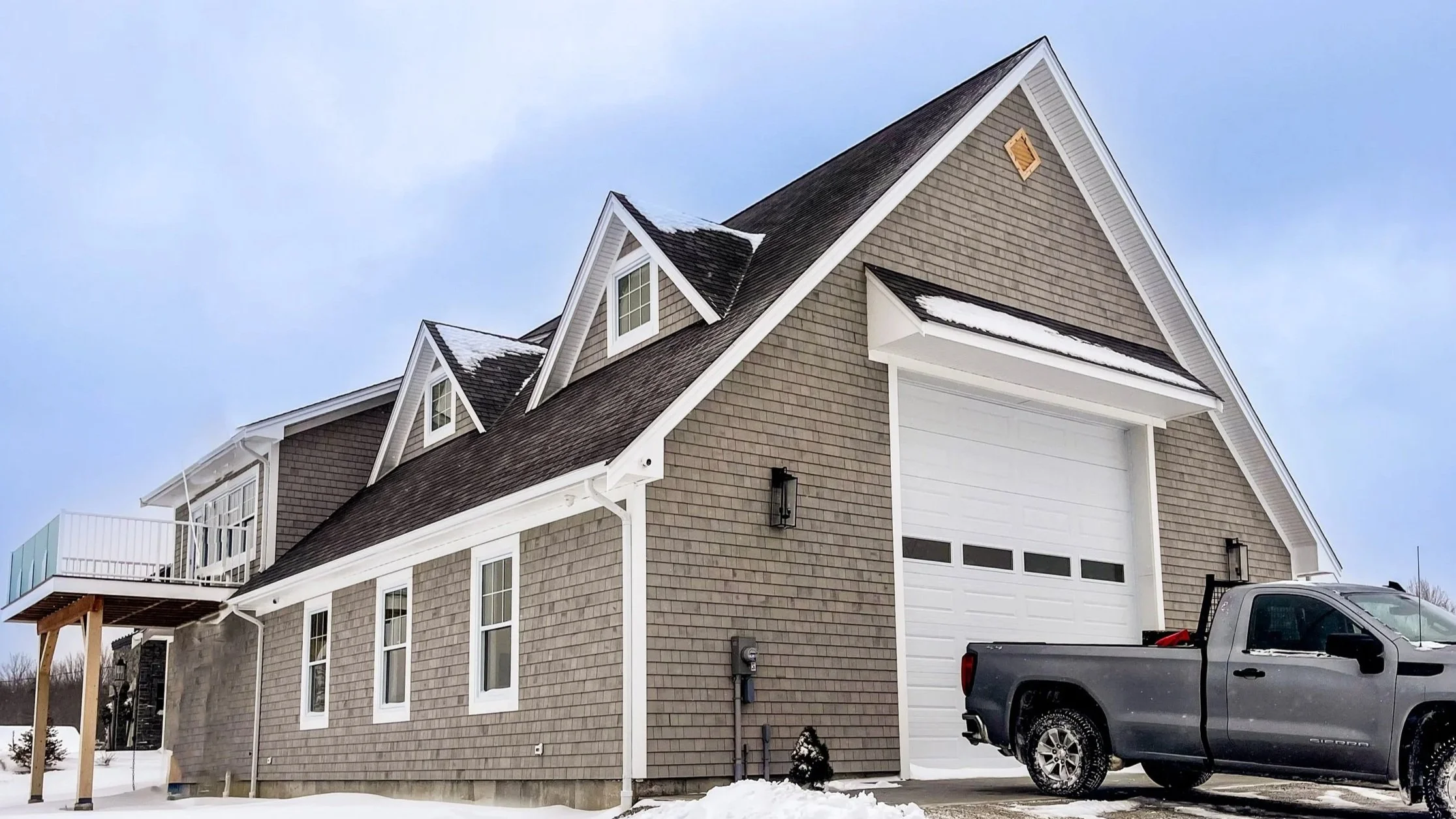 Completed custom home built by Concept Habitat in Indian Point, Nova Scotia, featuring grey shingle siding and a steep gabled roof.