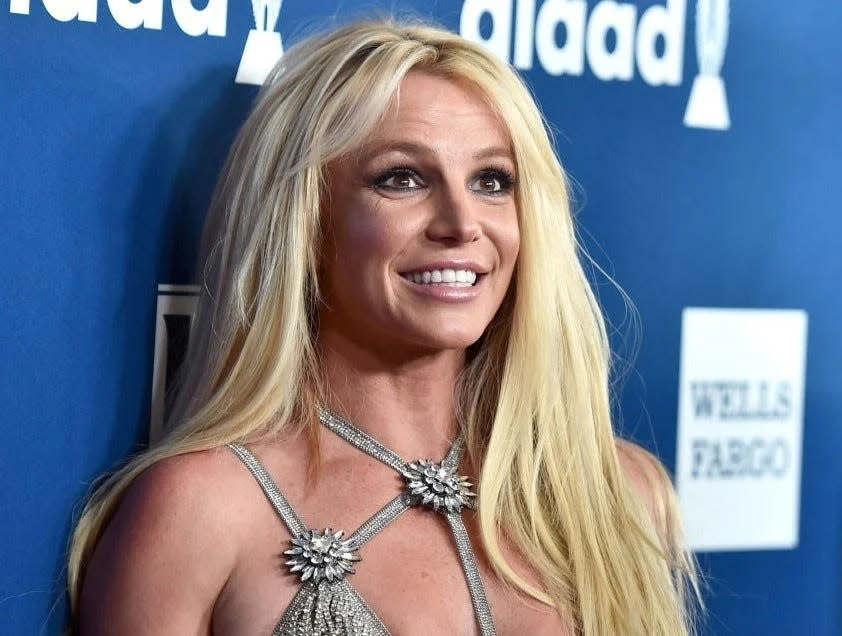 britney spears looking up and smiling on a red carpet