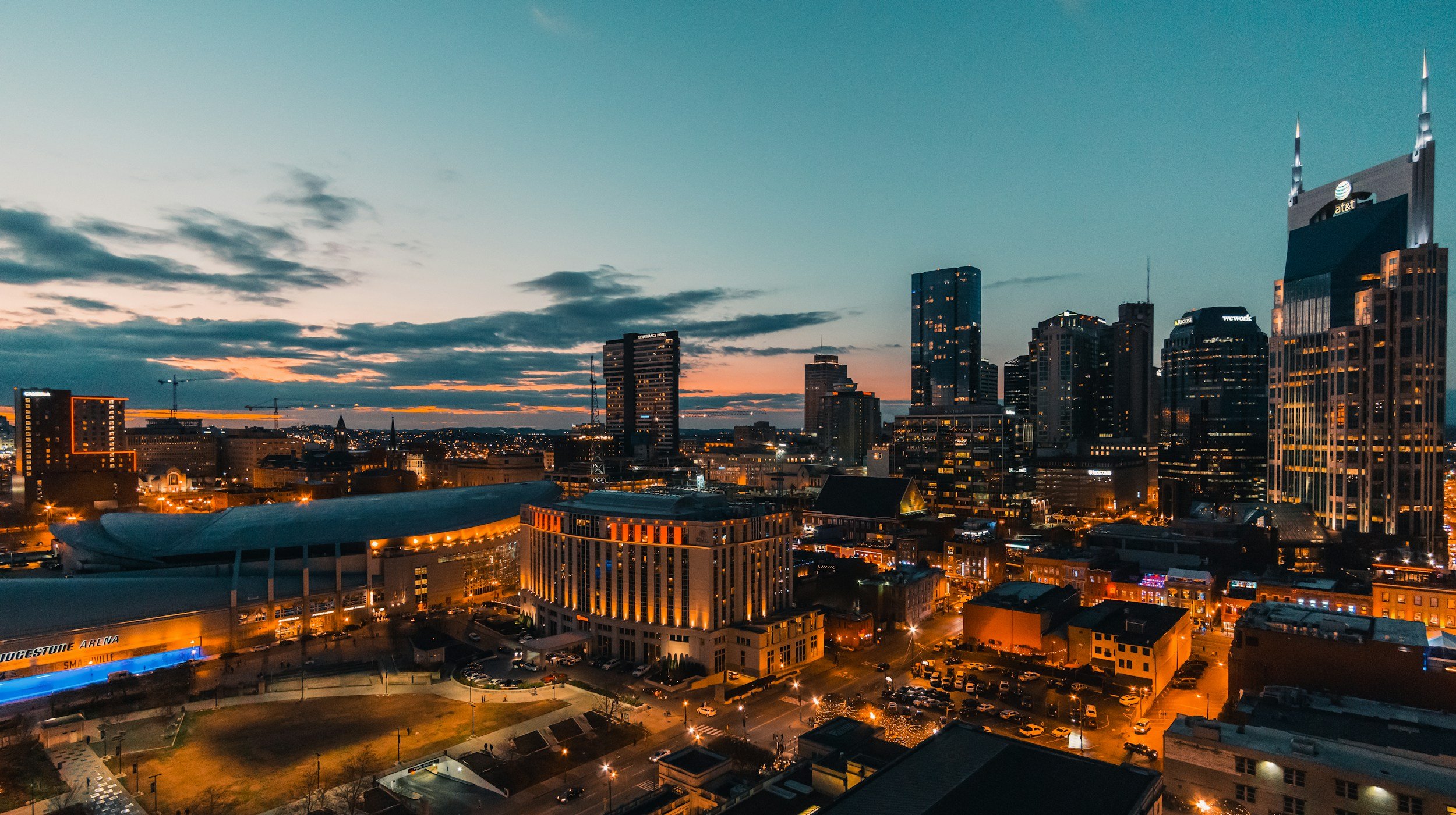 City skyline at dusk with illuminated buildings and streets.